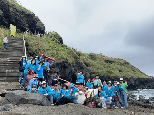 '영웅시대 제주' 회원 30여 명아 지난 21일 우도 검멀레 해안가 일대에 해양쓰레기 수거 등 환경정비 후 기념 사진을 찍고 있다.<임영웅 팬클럽 영웅시대 제공>
